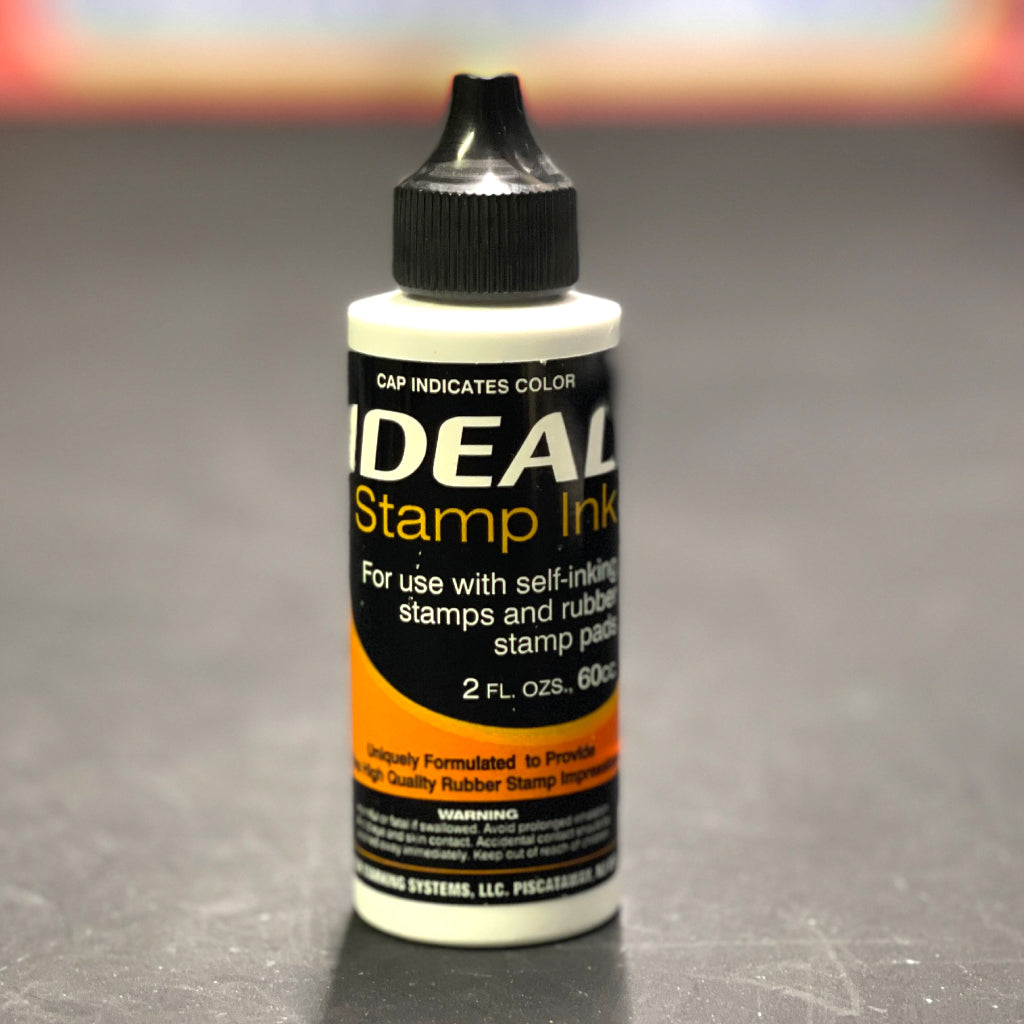 Bottle of Black Ideal Stamp Ink on a gray background